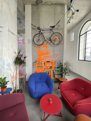 Möbel in einem Wohnzimmer in der Summer Lounge. Fahrrad hängt an der Wand. Viel Dekoration.